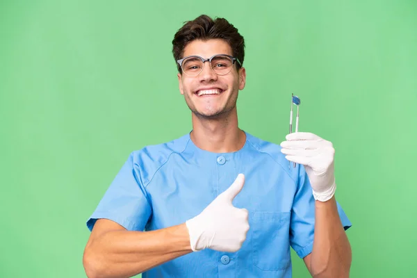 Jovem Dentista Homem Segurando Ferramentas Sobre Fundo Isolado Dando Gesto — Fotografia de Stock