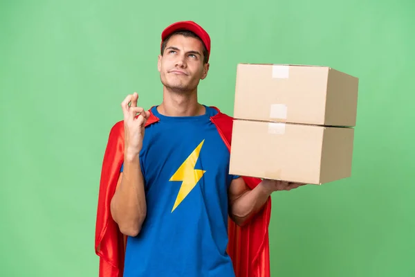 Super Hero Delivery Man Isolated Background Fingers Crossing Wishing Best — Stock Photo, Image