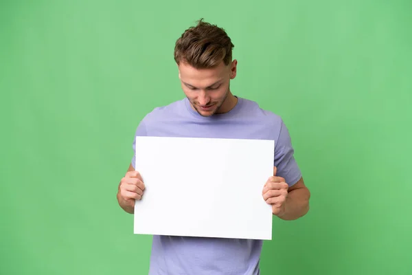 Young Blonde Caucasian Man Isolated Background Holding Empty Placard Looking — Stock Photo, Image