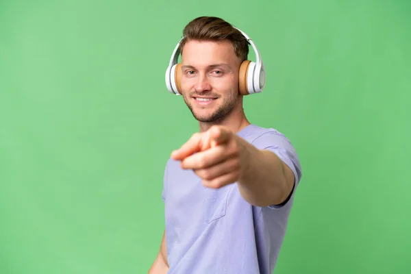 Jonge Blonde Blanke Man Geïsoleerde Achtergrond Luisteren Muziek Wijzen Naar — Stockfoto
