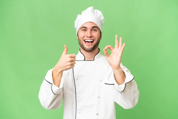 Młody Przystojny Szef Kuchni Człowiek Odizolowane Tło Pokazuje Znak Kciuk — Zdjęcie stockowe