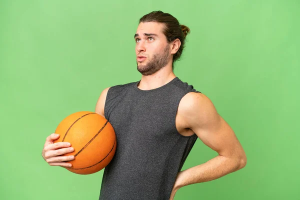 年轻的篮球运动员因努力工作而背痛 他的背景与外界格格不入 — 图库照片