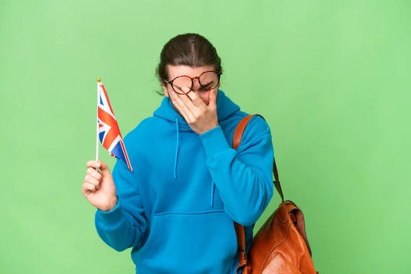 年轻英俊的男子举着英国国旗 背景偏僻 表情疲惫 — 图库照片