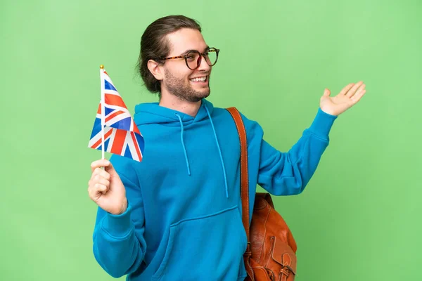 年轻英俊的男子举着英国国旗 在与世隔绝的背景下伸出手来邀请客人前来 — 图库照片