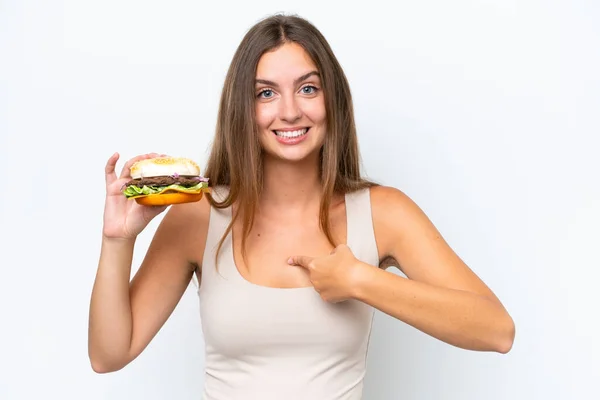 Młoda Ładna Kobieta Trzyma Hamburgera Białym Tle Zaskakującym Wyrazem Twarzy — Zdjęcie stockowe