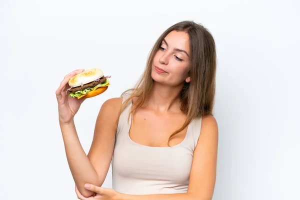 Νεαρή Όμορφη Γυναίκα Κρατώντας Ένα Burger Απομονώνονται Λευκό Φόντο Θλιβερή — Φωτογραφία Αρχείου