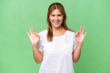 Orta yaşlı, beyaz bir kadın izole edilmiş arka planda iki eliyle 