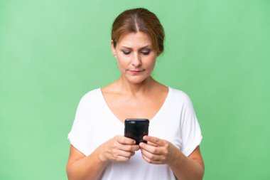 Orta yaşlı beyaz bir kadın cep telefonu kullanıyor.