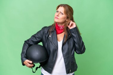 İzole edilmiş arka planda motosiklet kaskı olan orta yaşlı beyaz bir kadın şüpheleri var.