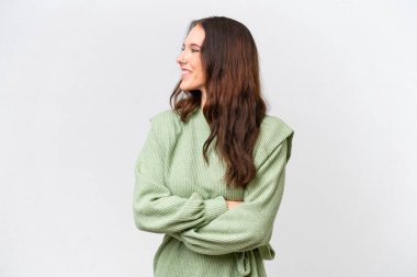 Beyaz arka planda yalıtılmış beyaz tenli genç bir kadın var.