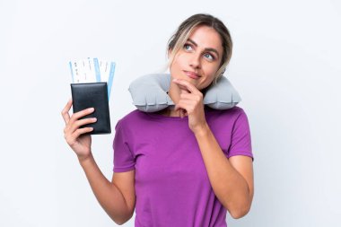 Şişirilebilir Seyahat Yastığı olan genç, güzel Uruguaylı kadın beyaz arka planda izole edilmiş ve yukarı bakıyor.