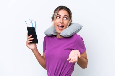 Şişirilebilir Seyahat Yastığı ile genç ve güzel Uruguaylı kadın beyaz arka planda yalnız ve sürpriz bir ifadeyle yan tarafa bakıyor.