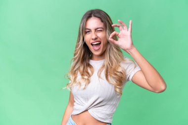 Genç Uruguaylı kadın izole edilmiş arka planda parmaklarıyla tamam işareti gösteriyor.