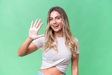 Genç Uruguaylı kadın tecrit edilmiş arka planda beş parmaklı sayıyor.