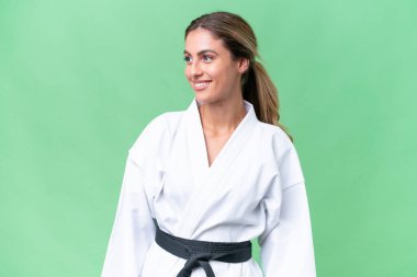 Genç Uruguaylı kadın izole edilmiş arka planda karate yapıyor. Yana bakıyor ve gülümsüyor.