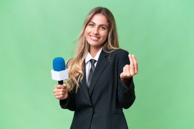 Genç, güzel Uruguaylı televizyon sunucusu izole bir arka planda para hareketi yapıyor.