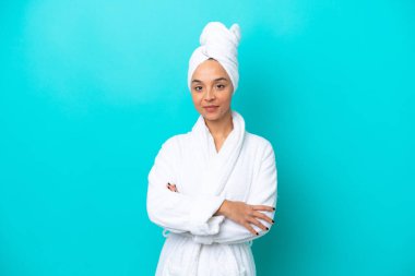 Bornozlu, mavi arka planda izole edilmiş genç bir kadın.