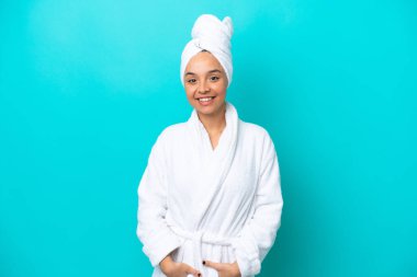 Bornozlu, mavi arka planda izole edilmiş genç bir kadın.