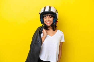 Sarı arka planda motosiklet kasklı genç Latin kadın.