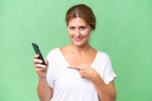 Donna Caucasica Mezza Età Sfondo Isolato Utilizzando Telefono Cellulare Indicandolo — Foto Stock
