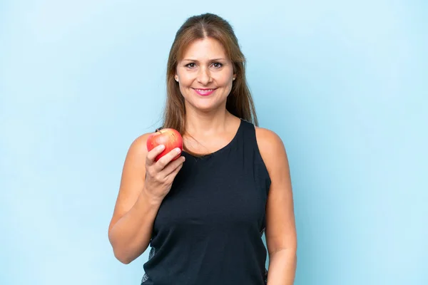 青の背景にリンゴで隔離された中年の白人女性 — ストック写真