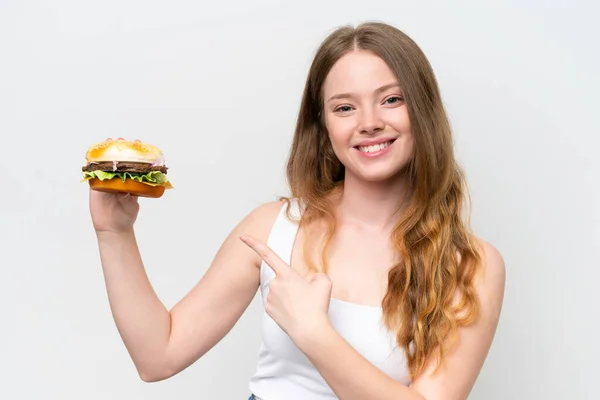 Młoda Ładna Kobieta Trzymając Hamburgera Białym Tle Wskazując — Zdjęcie stockowe