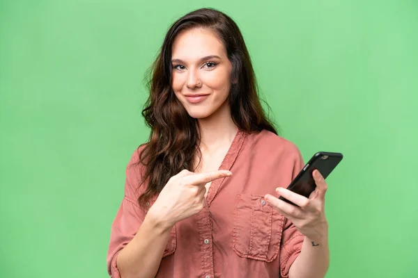 年轻的高加索女人在与世隔绝的背景下使用手机指指点点 — 图库照片