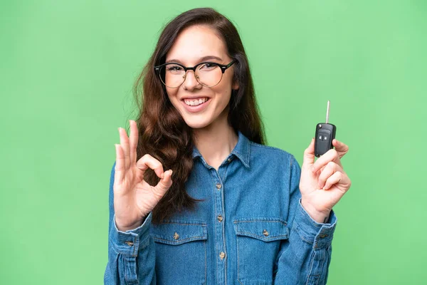 Молодая Белая Женщина Держит Ключи Машины Изолированном Фоне Показывая Знак — стоковое фото