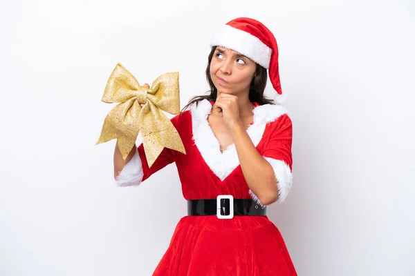 年轻的惊慌失措的女人穿得像个老太婆 手里拿着一把白色背景的圣诞弓 满腹狐疑 — 图库照片