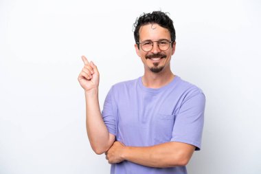 Bıyıklı genç adam beyaz arka planda izole edilmiş mutlu ve dik duruyor.