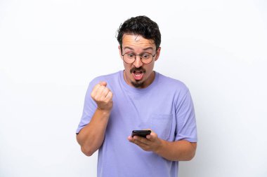 Bıyıklı genç adam beyaz arka planda izole edilmiş, şaşırmış ve bir mesaj gönderiyor.