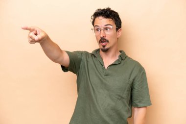 Beyazlı genç bir adam bej arka planda izole edilmiş.