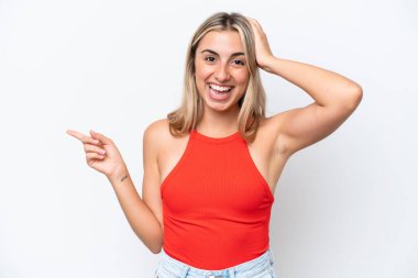 Beyaz arka planda izole edilmiş genç beyaz kadın şaşırmış ve işaret ediyor.