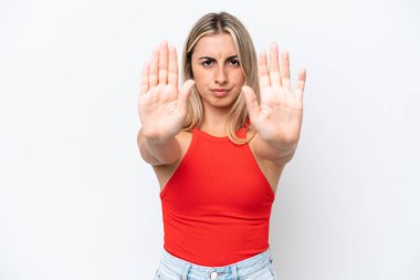 Beyaz arka planda izole edilmiş genç beyaz kadın dur hareketi yapıyor ve hayal kırıklığına uğruyor.