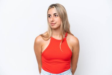 Beyaz arka planda izole edilmiş genç beyaz kadın yan tarafa bakıyor.