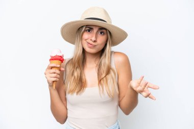 Beyaz arka planda izole edilmiş kornet dondurmalı beyaz bir kadın omuzlarını kaldırırken şüpheyle hareket ediyor.