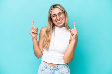 Mavi arka planda izole edilmiş beyaz bir kadın harika bir fikre işaret ediyor.