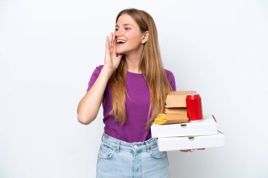 Beyaz arka planda izole edilmiş fast food tutan güzel sarışın kadın ağzı sonuna kadar açık bağırıyor.