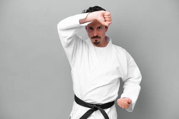 Joven Caucásico Aislado Sobre Fondo Gris Haciendo Karate —  Fotos de Stock