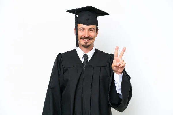 Fiatal Egyetemi Diplomás Férfi Elszigetelt Fehér Háttér Mosolyog Mutatja Győzelem — Stock Fotó