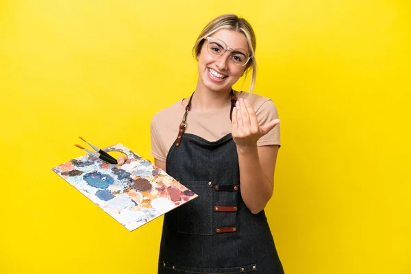 Młoda Artystka Rasy Kaukaskiej Trzymająca Paletę Odizolowaną Żółtym Tle Zapraszając — Zdjęcie stockowe