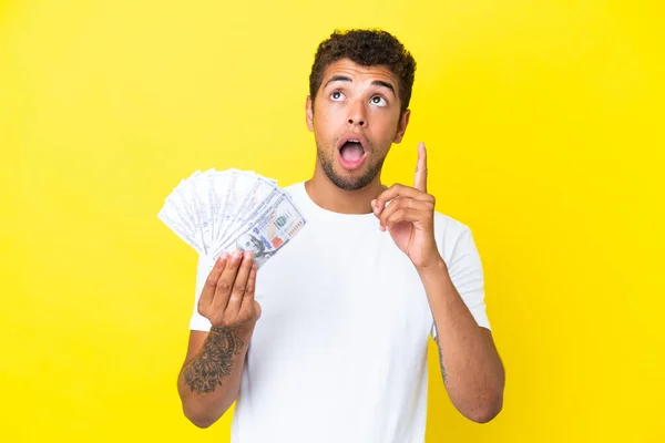 Jonge Braziliaanse Man Neemt Veel Geld Geïsoleerd Gele Achtergrond Denkend — Stockfoto