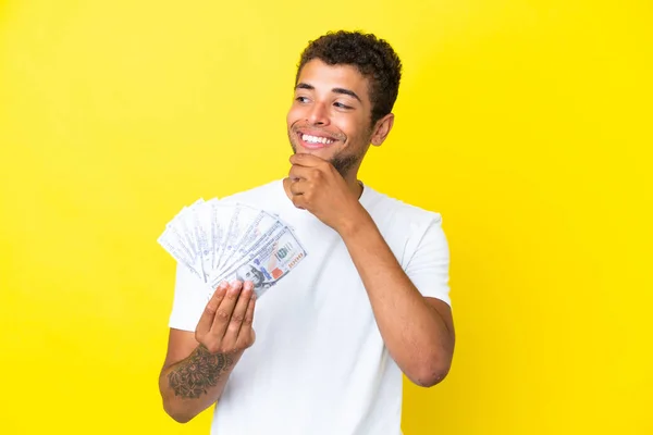 Jonge Braziliaanse Man Neemt Veel Geld Geïsoleerd Gele Achtergrond Kijken — Stockfoto