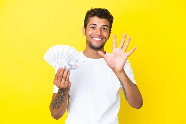Jonge Braziliaanse Man Neemt Veel Geld Geïsoleerd Gele Achtergrond Tellen — Stockfoto