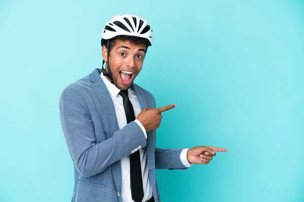 年轻的巴西商人 戴着蓝色背景的自行车头盔 惊讶而又有针对性地侧身而坐 — 图库照片