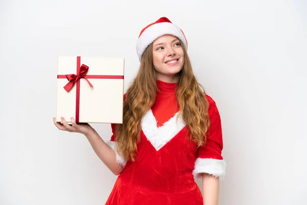 若いですCaucasian女性とともにクリスマスドレス保持ギフト隔離された上に白い背景上を見ながら笑顔 — ストック写真