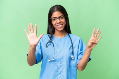 Genç Afrikalı Amerikalı hemşire, tecrit edilmiş arka planda dokuz parmaklı sayıyor.