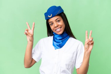 Uçak hostesi Afro-Amerikan kadın izole edilmiş arka planda zafer işaretini iki elle gösteriyor.