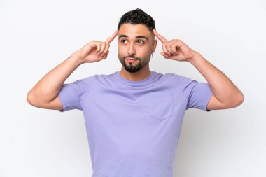 Genç Arap yakışıklı adam beyaz arka planda izole edilmiş. Şüpheleri ve düşünceleri var.