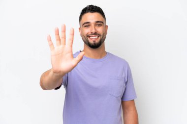 Beyaz arka planda izole edilmiş genç Arap yakışıklı adam parmaklarıyla beşi sayıyor.